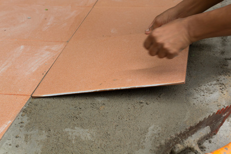 泥水匠平铺在家里，在瓷砖地板胶粘剂装修