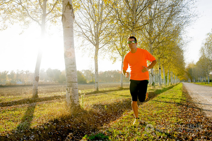运动青年男子在路边跑道外跑步