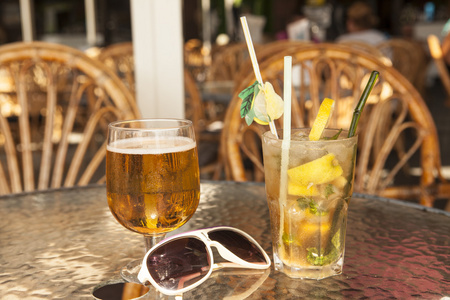 迷离的杯啤酒和鸡尾酒用玻璃桌上的橄榄照片