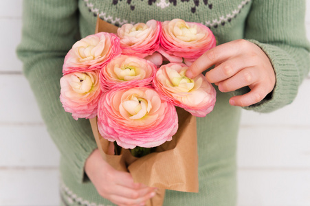 在孩子的手中，母亲的一天概念软粉红色花毛茛的美丽花束