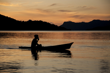 海上吉普赛人在日出时独木舟照片