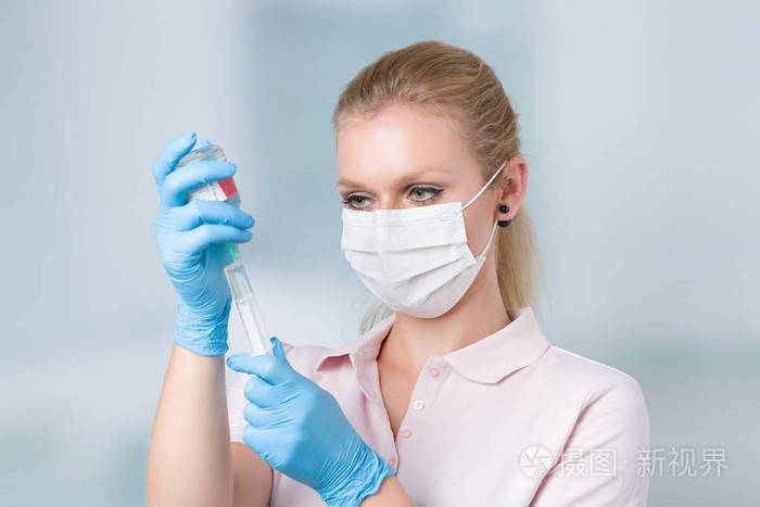 拉起一个注射器,背景在诊所里的护士