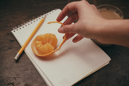 老木背景上橘子笔记本铅笔咖啡