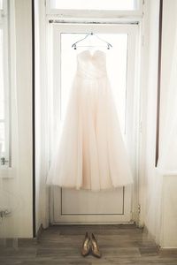 时尚婚纱礼服的新娘挂在窗口附近
