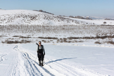 北欧的步进式成年男子在冬天，阿尔泰山区徒步雪