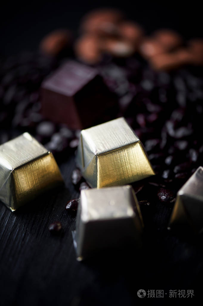 糖果在金色箔杏仁和巧克力躺在黑暗的背景中的向日葵种子工作室