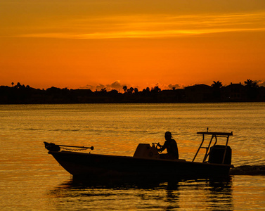 日落与船上的国米在 Belleair 布拉夫斯，佛罗里达州沿海的剪影