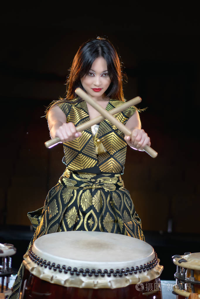 亚洲长发鼓手美女鼓棒工作室拍摄一个黑暗的背景