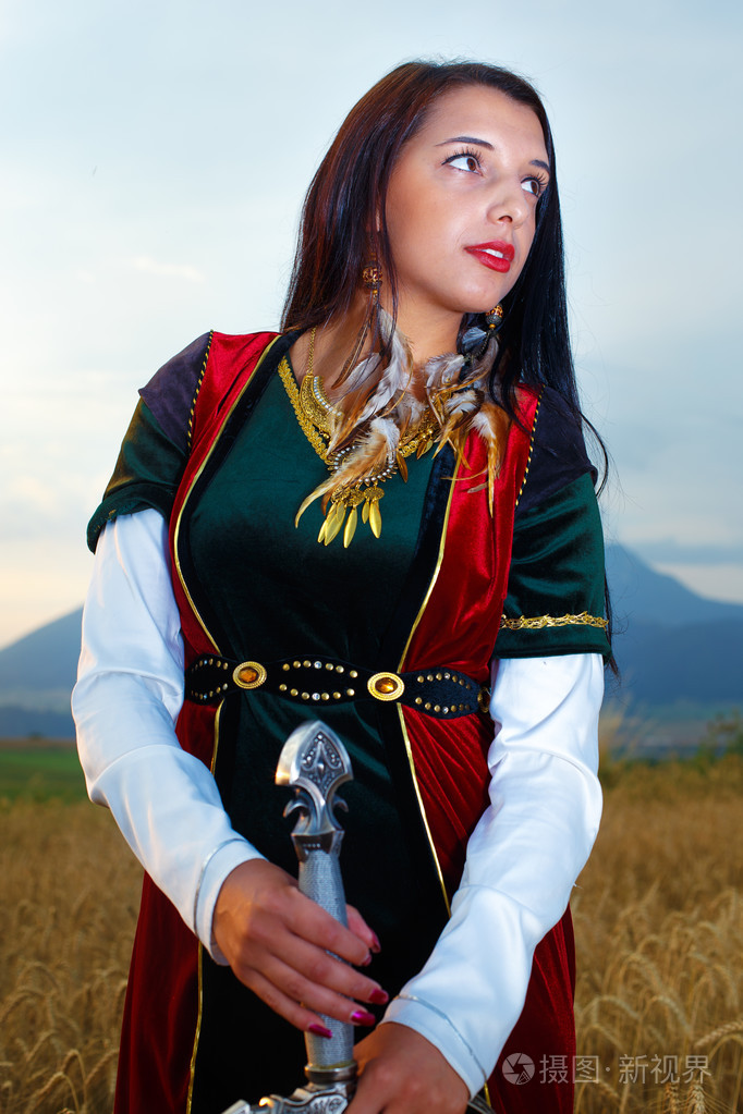 美丽性感的女战士带剑. 土地背景.