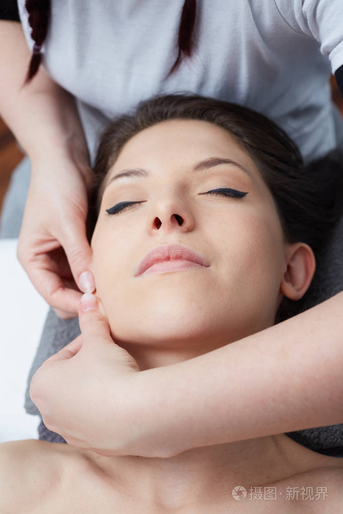 女性享受放松面部按摩的美容 spa 中心