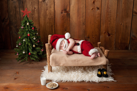 睡眠穿着圣诞老人的衣服，留着胡子的初生男婴