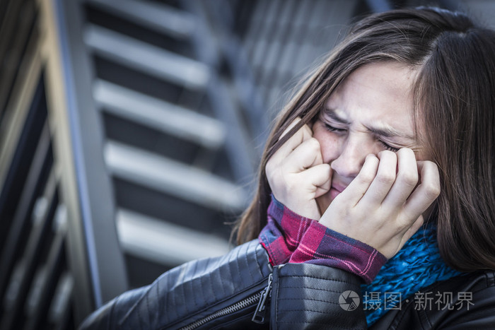 哭的青少年中青年在楼梯上的女孩
