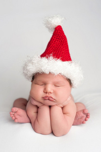 可爱的新生婴儿女孩戴着圣诞的帽子