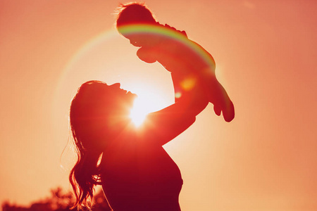 母亲和小宝宝一起玩在日落时分