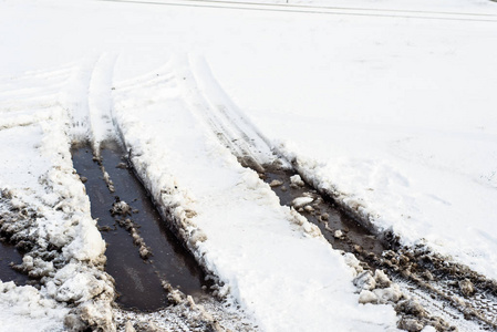 在雪，冬季的质地，车胎和融化的水洼路的背景