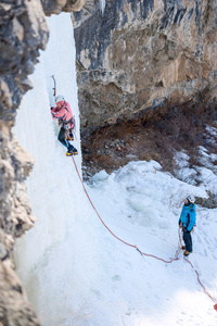一群登山者攀登一个冰冻的瀑布图片