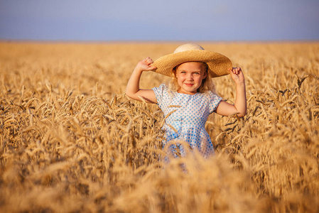 可爱的小女孩玩在小麦夏田