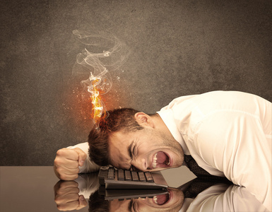敲电脑悲伤的商务人士头着火照片