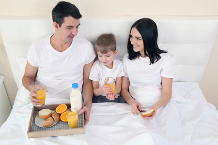 家庭早餐与橙汁和包子在床上
