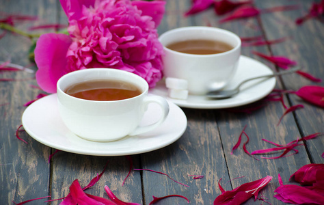 热的茶和牡丹花瓣上黑暗