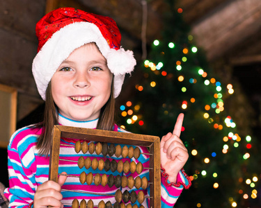 快乐的孩子在等待一个奇迹的圣诞帽子的女孩