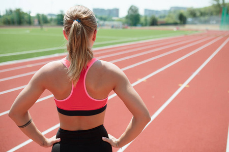 年轻不可识别运动女运动员在运动服准备在体育场跑道回上运行视图