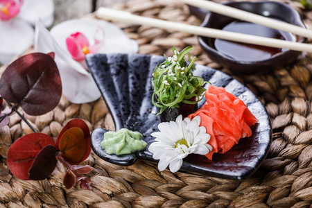 与海藻 芝麻 黑版上竹凉席上奶油芝士寿司京坎 maki 装饰着花朵。日本料理。选择性的焦点