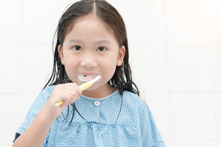 快乐可爱的亚洲女孩在卫生间刷牙