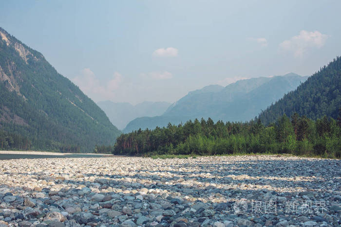 山区河流之间的森林和岩石背景山峰上的美丽景色