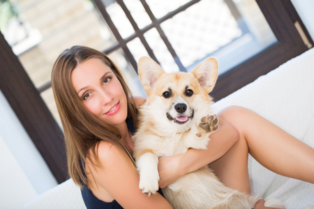 年轻女人保持威尔士科基犬小狗