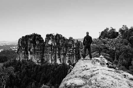 登山者人在陡峭的悬崖和山手表为黑色。岩石的黑暗轮廓