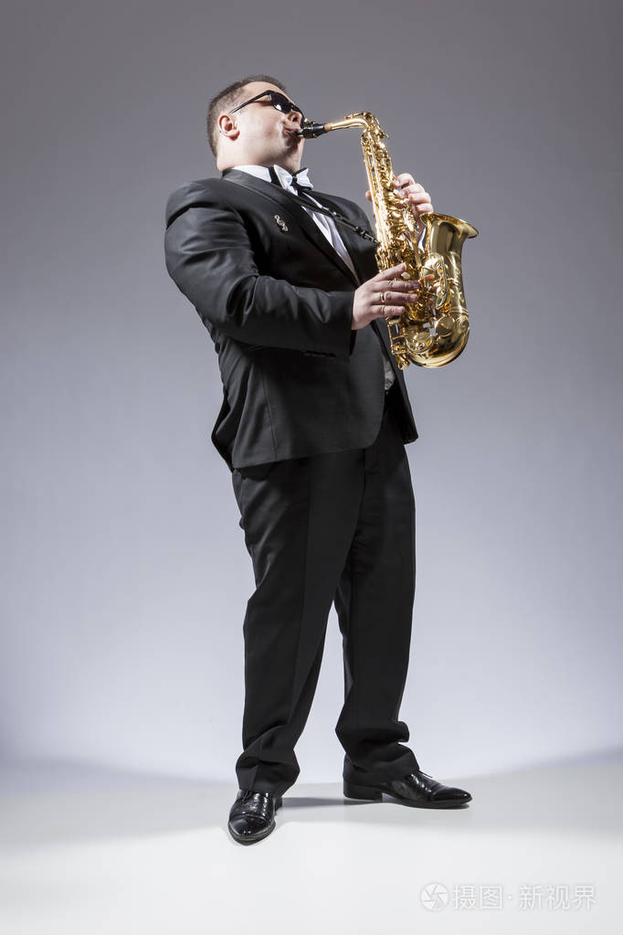 满长的白种人萨克斯风吹奏,在工作室的太阳镜的画像