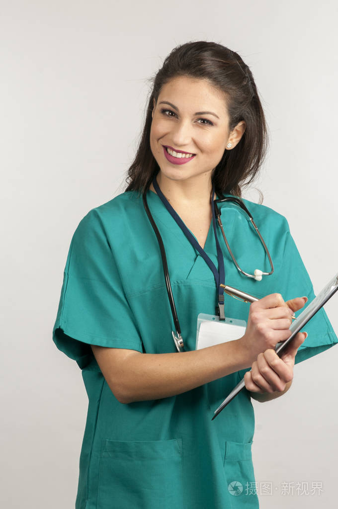 女医生在手术件白色上衣和白色背景上孤立的听诊器站照片-正版商用