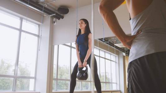 女人做蹲起动作与重量在健身房锻炼