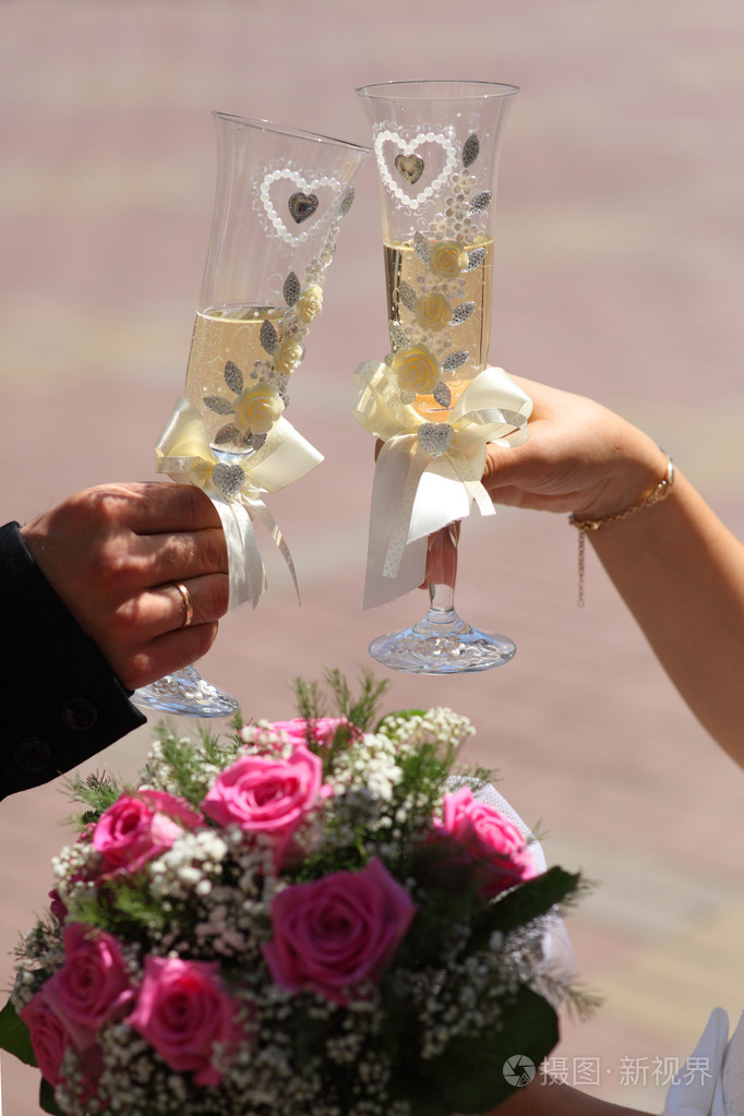 原始的婚礼眼镜在手中的新娘和新郎新娘和新郎抱着香槟杯香槟祝酒