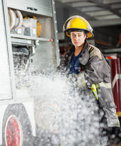在消防局喷洒水的自信 Firewoman