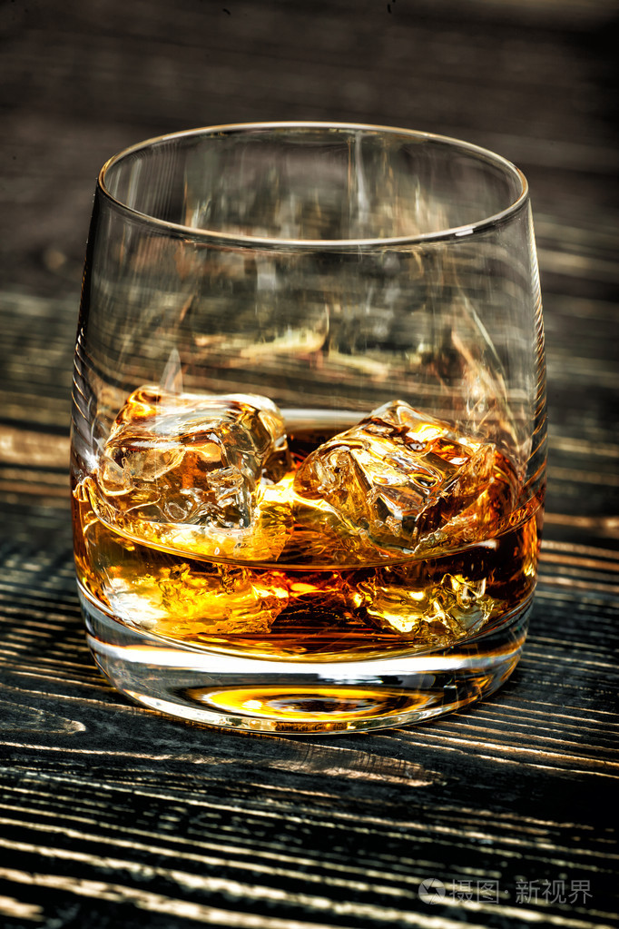 威士忌加冰在黑色的木背景