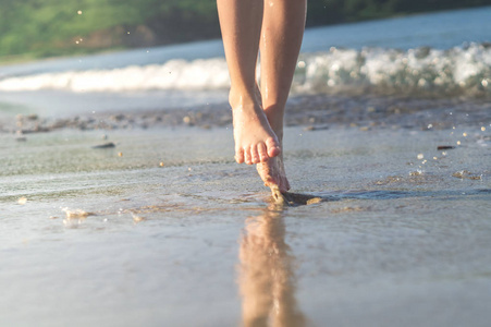 女孩跑沙滩岸边泼水在蓝色的大海