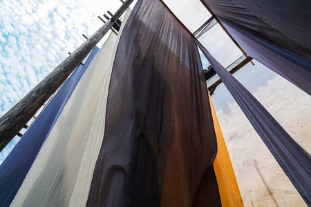 悬挂晾干后传统染色工艺的彩色织物照片