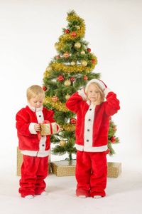 可爱的小孩子们分享附近树上的圣诞礼物
