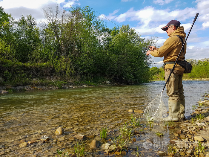 在山区河流钓鱼钓鳟鱼捕鱼的渔夫