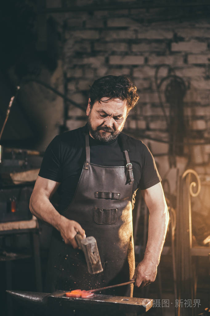 铁匠工作金属在铁匠铺里铁砧上锤