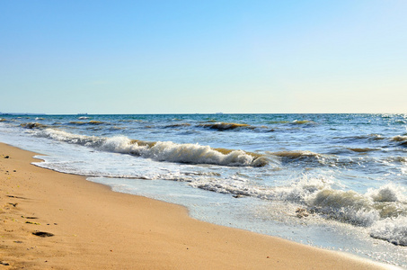 海浪冲刷着沙滩蓝天的衬托