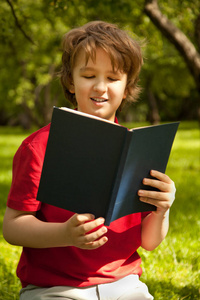 绿色的夏天苹果树木公园里读书的青少年男孩