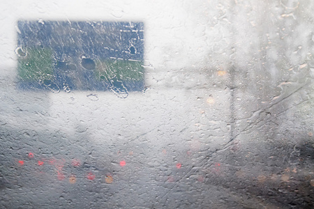 模糊的交通路上雨的硬雨天白天滴溅挡风玻璃