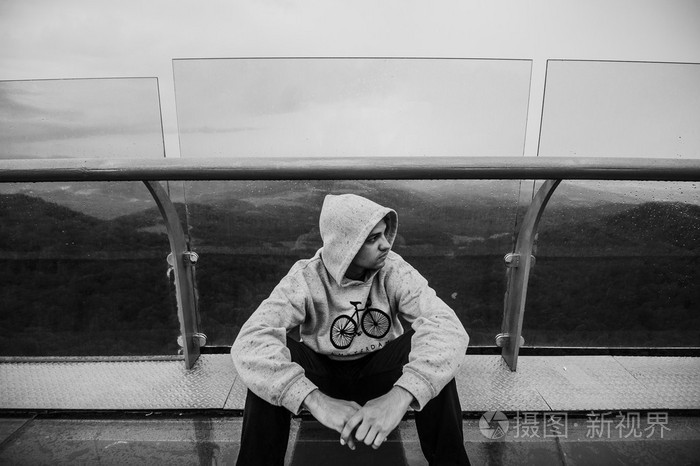 寂寞的时刻男人坐在山顶岩石思维累了放松