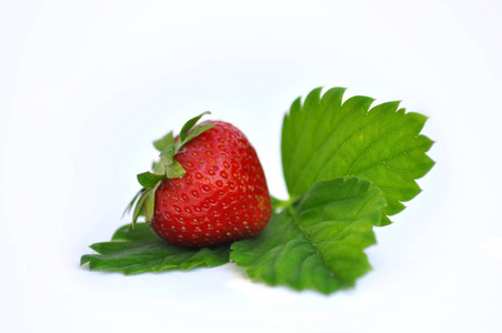白色背景上绿叶上的多汁草莓