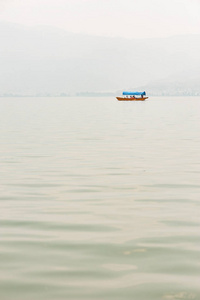 小船在湖上的阴霾与背景山图片
