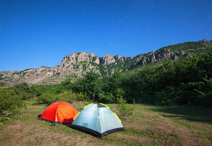 在一片空地，在满天星斗的天空与山峰山脉旅游帐篷