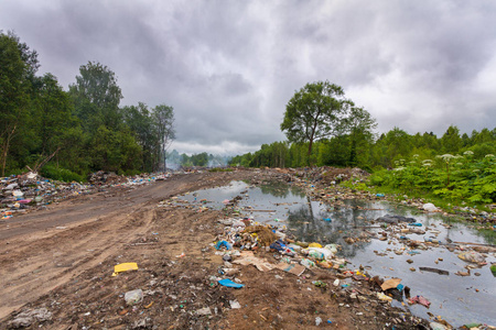 填埋或倾倒在污染和毒害环境的肮脏的水中的家庭垃圾和垃圾。污染概念地球